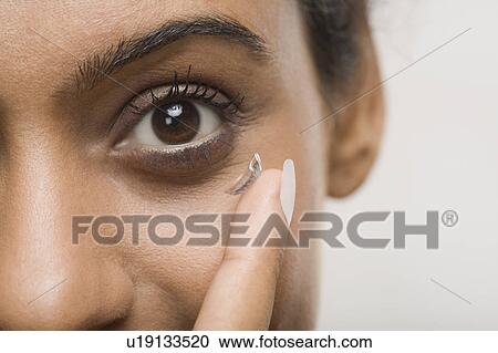 Woman putting on contact lens View Large Photo Image Stock Image - Woman putting on contact lens. Fotosearch