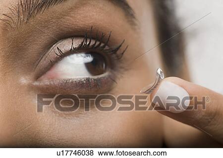 Woman putting on contact lens View Large Photo Image Stock Photo - Woman putting on contact lens. Fotosearch