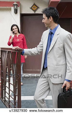 Woman saying goodbye to her husband leaving for office View Large Photo Image Stock Image - Woman saying goodbye to her husband leaving for office. Fotosearch