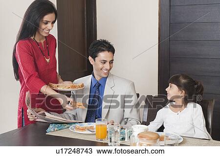 Woman serving breakfast to her family View Large Photo Image Stock Image - Woman serving breakfast to her family. Fotosearch