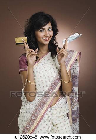 Stock Photo - Woman showing a credit card and a currency note. Fotosearch