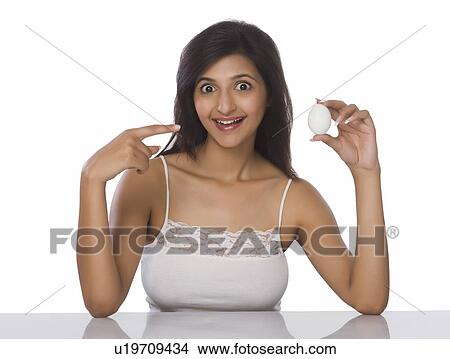 Woman showing an egg and smiling View Large Photo Image Picture - Woman showing an egg and smiling. Fotosearch