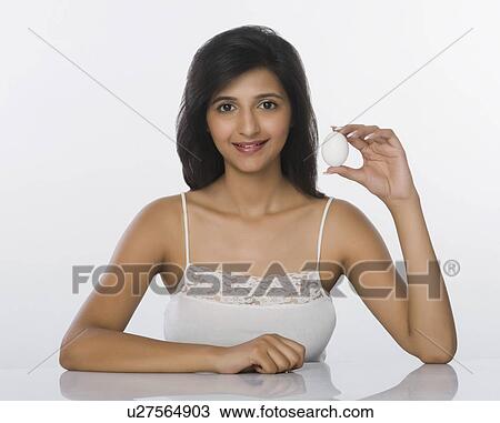 Stock Image - Woman showing an egg and smiling. Fotosearch