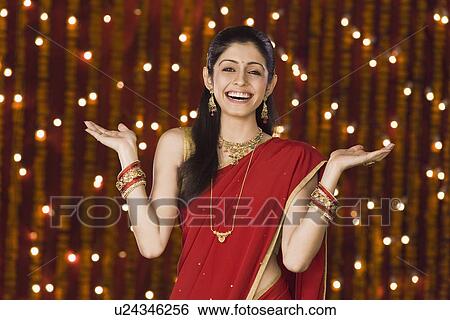 Woman shrugging in front of Diwali decoration View Large Photo Image Stock Photograph - Woman shrugging in front of Diwali decoration. Fotosearch