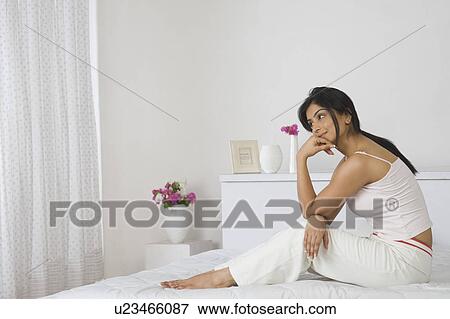 Woman sitting on the bed and thinking View Large Photo Image Stock Photo - Woman sitting on the bed and thinking. Fotosearch