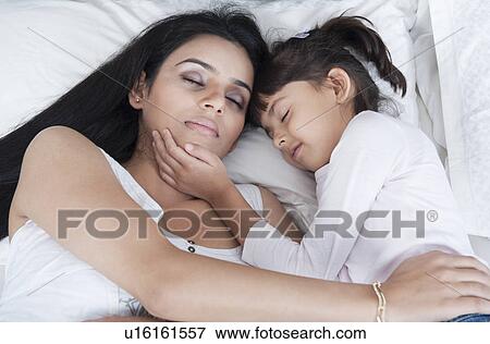 Woman sleeping with her daughter View Large Photo Image Stock Photo - Woman sleeping with her daughter. Fotosearch