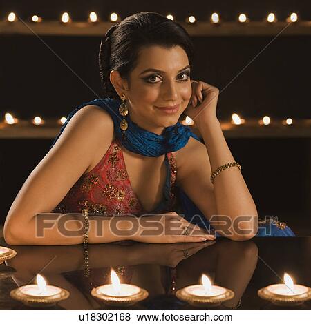 Woman smiling near oil lamps at Diwali festival View Large Photo Image Stock Photo - Woman smiling near oil lamps at Diwali festival. Fotosearch