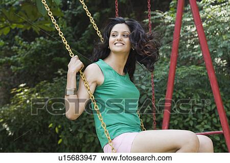 Stock Photo - Woman smiling on a swing. Fotosearch