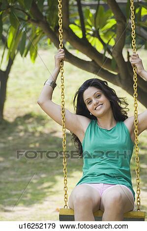 Stock Photo - Woman smiling on a swing. Fotosearch