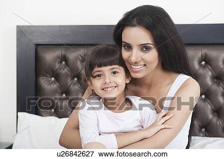 Stock Photo - Woman smiling with her daughter. Fotosearch