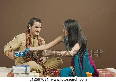 Stock Image - Woman snatching gift from her brother at the festival of Rakhi. Fotosearch