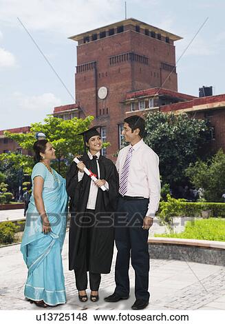 Woman standing with her parents and holding her diploma View Large Photo Image Stock Photo - Woman standing with her parents and holding her diploma. Fotosearch
