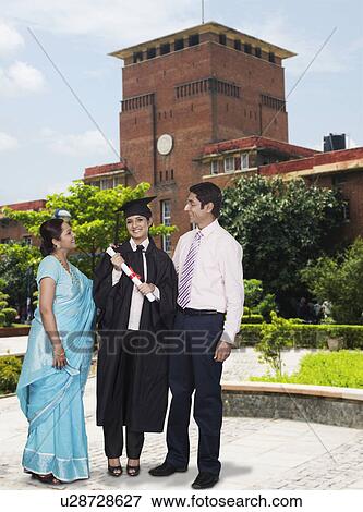 Stock Photo - Woman standing with her parents and holding her diploma. Fotosearch