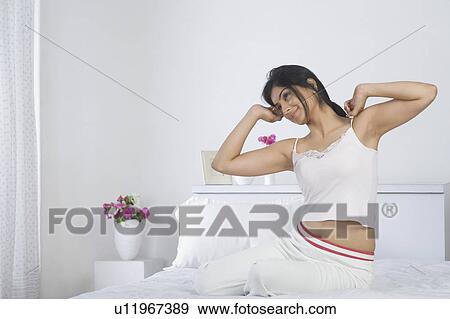 Woman stretching her arms on the bed View Large Photo Image Stock Photo - Woman stretching her arms on the bed. Fotosearch