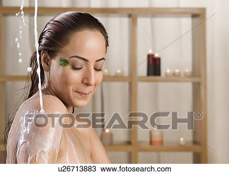 Stock Image - Woman taking a milk bath in a health spa. Fotosearch