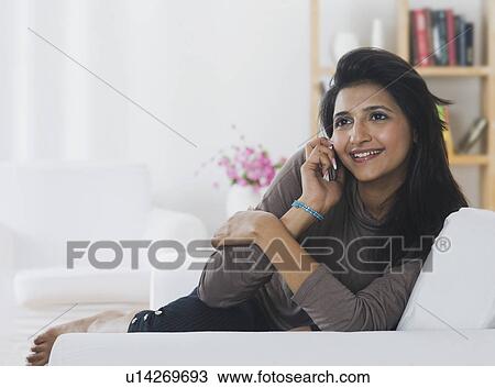 Woman talking on a mobile phone and smiling View Large Photo Image Stock Image - Woman talking on a mobile phone and smiling. Fotosearch