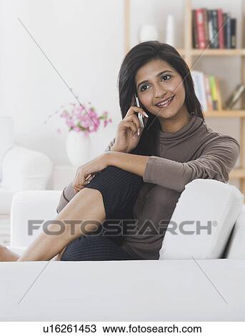 Stock Image - Woman talking on a mobile phone and smiling. Fotosearch