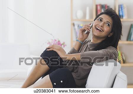 Stock Image - Woman talking on a mobile phone and smiling. Fotosearch