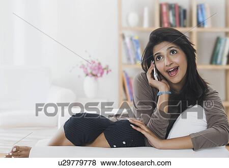 Woman talking on a mobile phone and smiling View Large Photo Image Stock Photo - Woman talking on a mobile phone and smiling. Fotosearch