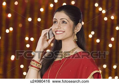 Woman talking on mobile phone in front of Diwali decoration View Large Photo Image Stock Photograph - Woman talking on mobile phone in front of Diwali decoration. Fotosearch