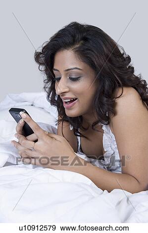 Woman text messaging on a mobile phone View Large Photo Image Stock Photo - Woman text messaging on a mobile phone. Fotosearch