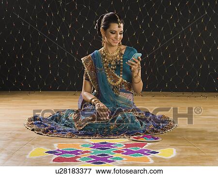 Woman text messaging on a mobile phone near rangoli View Large Photo Image Stock Photo - Woman text messaging on a mobile phone near rangoli. Fotosearch