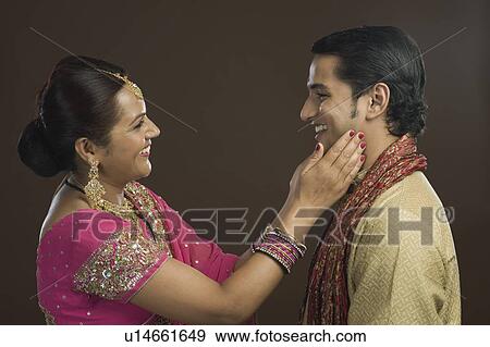 Stock Photo - Woman touching cheeks of her son. Fotosearch