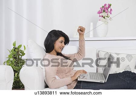 Woman using a laptop and looking excited View Large Photo Image Stock Image - Woman using a laptop and looking excited. Fotosearch