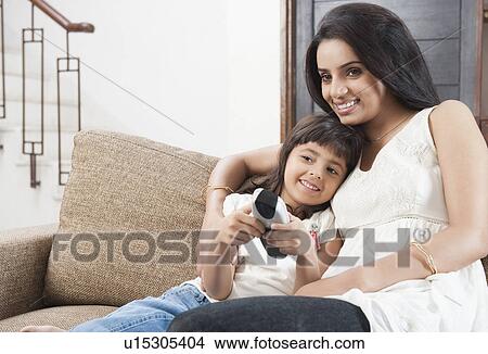 Picture - Woman watching television with her daughter. Fotosearch