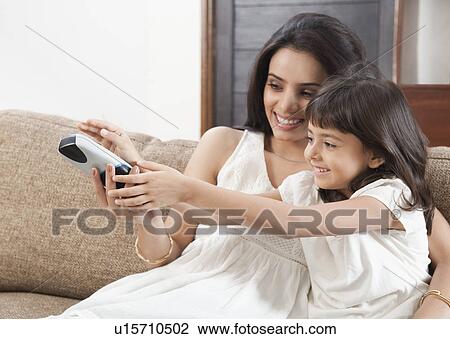 Woman watching television with her daughter View Large Photo Image Stock Image - Woman watching television with her daughter. Fotosearch