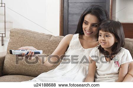 Woman watching television with her daughter View Large Photo Image Stock Photo - Woman watching television with her daughter. Fotosearch