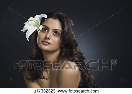 Stock Image - Woman wearing flowers and day dreaming. Fotosearch