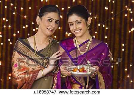 Women holding a pooja thali and smiling View Large Photo Image Stock Photo - Women holding a pooja thali and smiling. Fotosearch