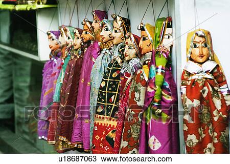 Stock Image - Wooden puppets hanging at a market stall, Delhi, India. Fotosearch