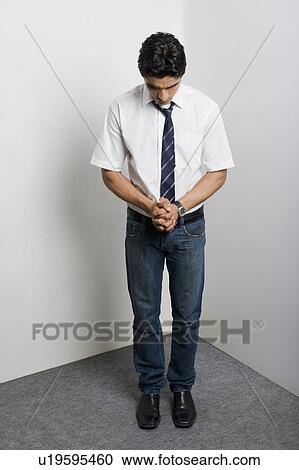 Stock Image - Worried university student standing in the corner. Fotosearch