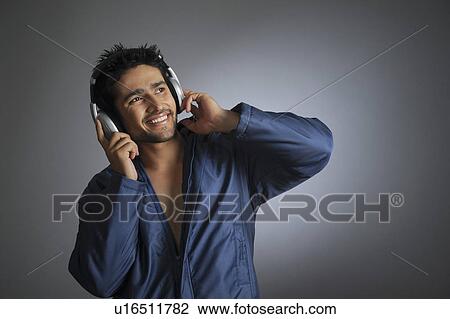 Young man listening to music with headphones View Large Photo Image Stock Image - Young man listening to music with headphones. Fotosearch