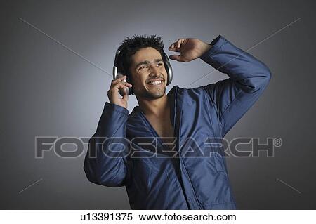 Young man listening to music with headphones View Large Photo Image Stock Photography - Young man listening to music with headphones. Fotosearch