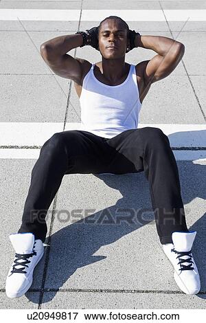 Athlete doing sit ups on sidewalk View Large Photo Image Stock Photo - Athlete doing sit ups on sidewalk. Fotosearch