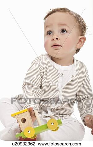 Baby playing with wooden train View Large Photo Image Stock Image - Baby playing with wooden train. Fotosearch