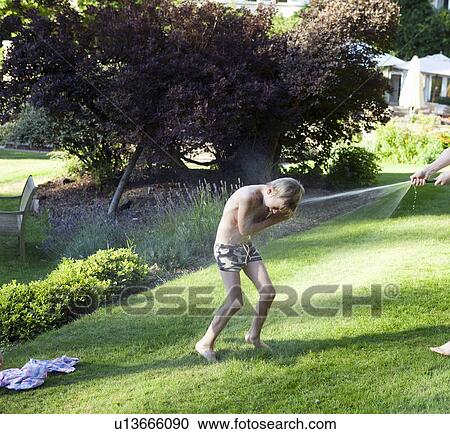 Boy being sprayed by hose outdoors View Large Photo Image Stock Image - Boy being sprayed by hose outdoors. Fotosearch