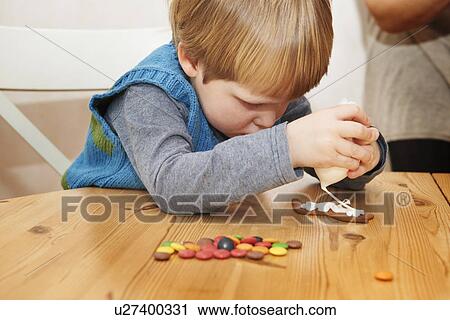 Boy decorating gingerbread cookie View Large Photo Image Stock Image - Boy decorating gingerbread cookie. Fotosearch