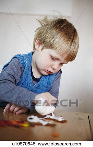 Stock Photograph - Boy decorating gingerbread cookies. Fotosearch
