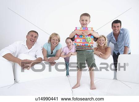 Boy opening gift with family View Large Photo Image Stock Image - Boy opening gift with family. Fotosearch