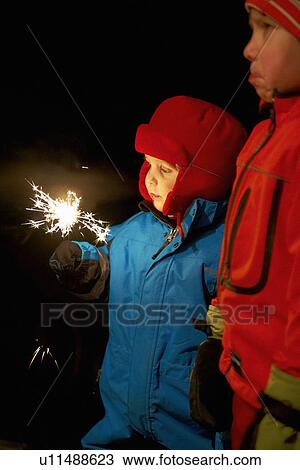 Boy playing with sparkler outdoors View Large Photo Image Stock Image - Boy playing with sparkler outdoors. Fotosearch