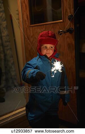Stock Photo - Boy playing with sparkler outdoors. Fotosearch