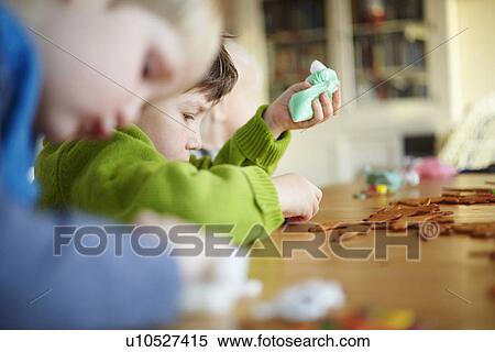 Stock Photography - Boys decorating gingerbread cookies. Fotosearch