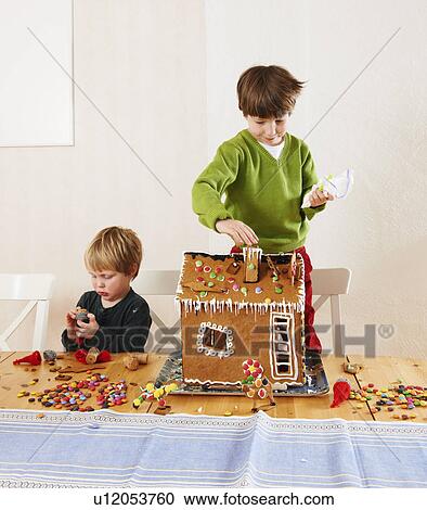 Boys decorating gingerbread house View Large Photo Image Stock Image - Boys decorating gingerbread house. Fotosearch