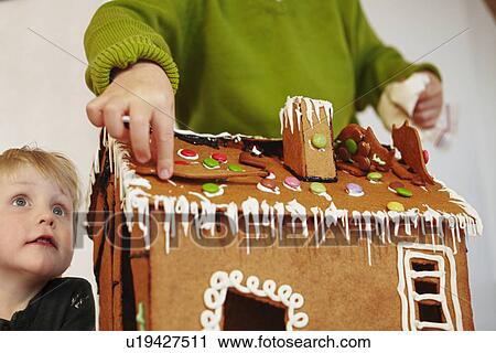 Boys decorating gingerbread house View Large Photo Image Stock Image - Boys decorating gingerbread house. Fotosearch