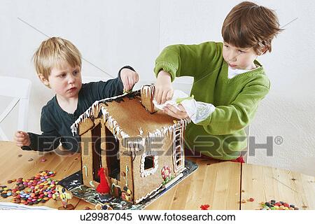 Boys decorating gingerbread house View Large Photo Image Stock Photography - Boys decorating gingerbread house. Fotosearch