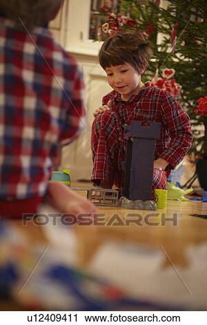 Stock Image - Boys opening Christmas gifts. Fotosearch